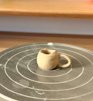 Taza de barro sobre arena rastrillada