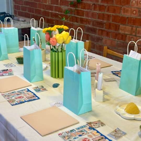 Mesa de taller con bolsas y material gráfico